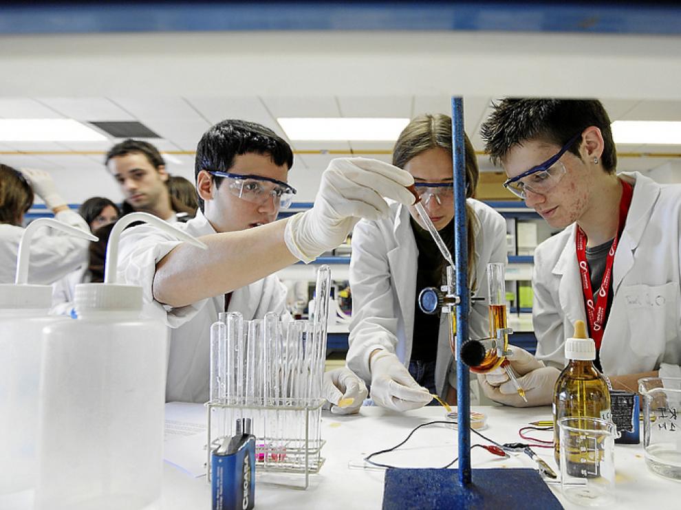 Tres alumnos de bachillerato experimentan en un laboratorio de la Facultad de Ciencias.