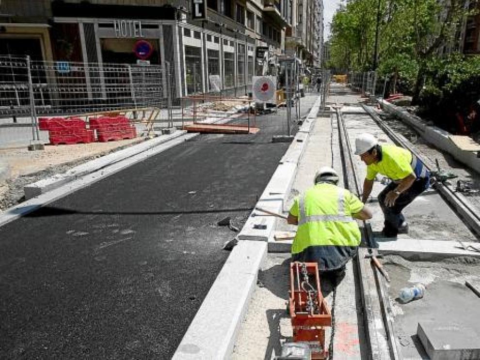 Dos operarios trabajan en la plataforma tranviaria, ayer por la mañana.