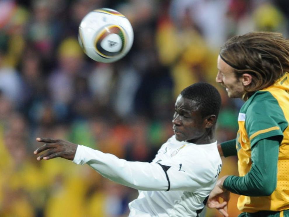 El defensa de Ghana, Jonathan Mensah (izquierda) busca el balón ante el australiano Josh Kennedy