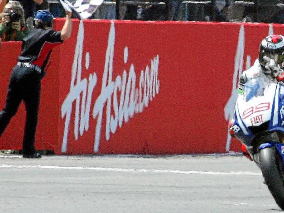 El piloto español de Yamaha Jorge Lorenzo entra victorioso en la meta del circuito de Silverstone.