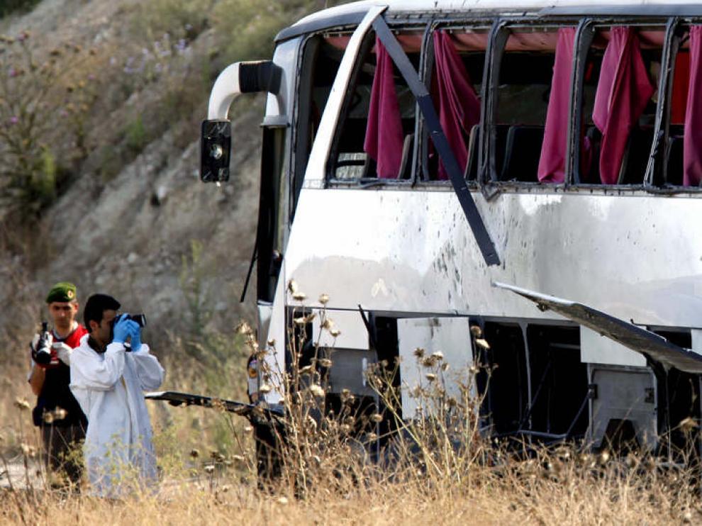 Los agentes revisan uno de los autobuses afectados por la explosión.