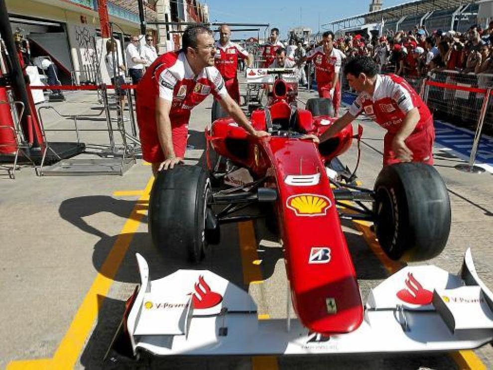 Los mecánicos de Ferrari empujan el monoplaza de Fernando Alonso a boxes del circuito de Valencia.