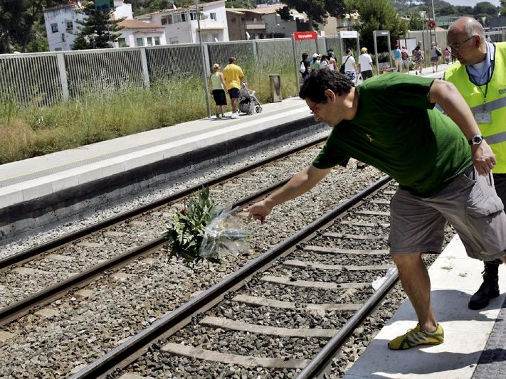 Un viajero arroja un ramo de flores en el lugar del accidente