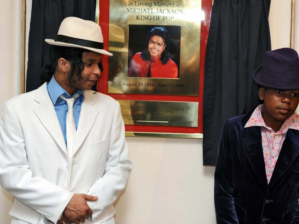 Dos actores del musical 'Thriller' junto a una placa que conmemora el aniversario de la muerte de Michael