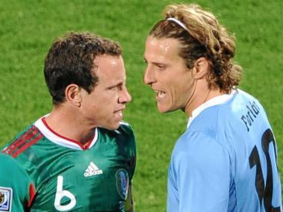 Diego Forlán se encara con un rival.