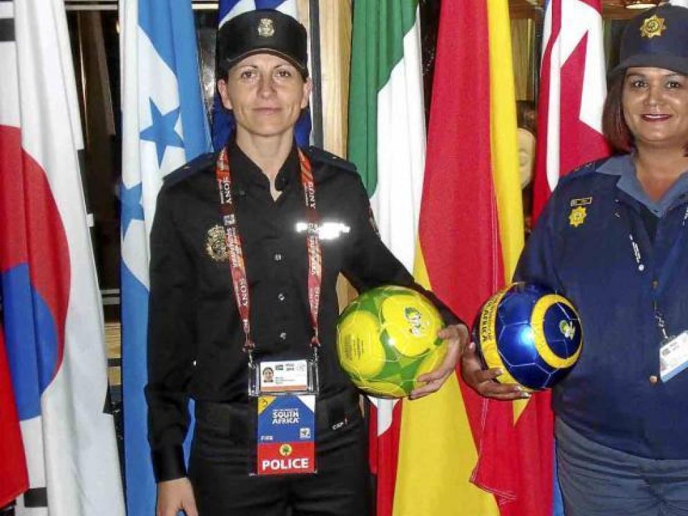 Silvia (a la izquierda), con una policía sudafricana, en el interior del estadio de Pretoria, donde ayer jugó España contra Chile.