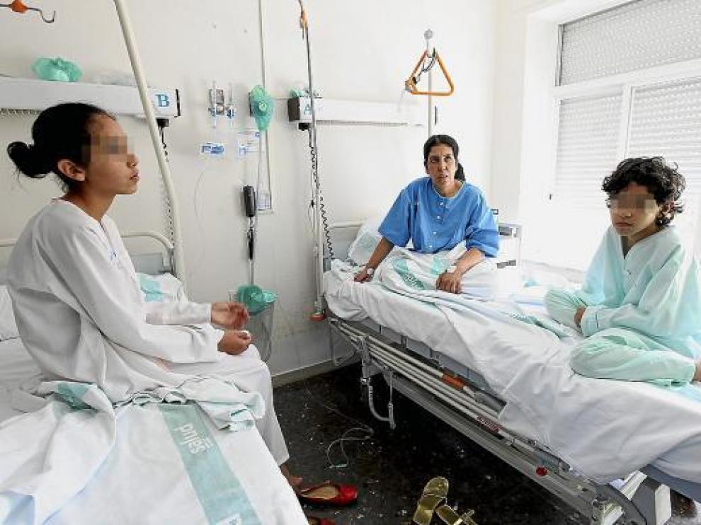 Zulica, en el centro, con dos hijas, en la habitación el hospital donde se recuperan de la intoxicación.
