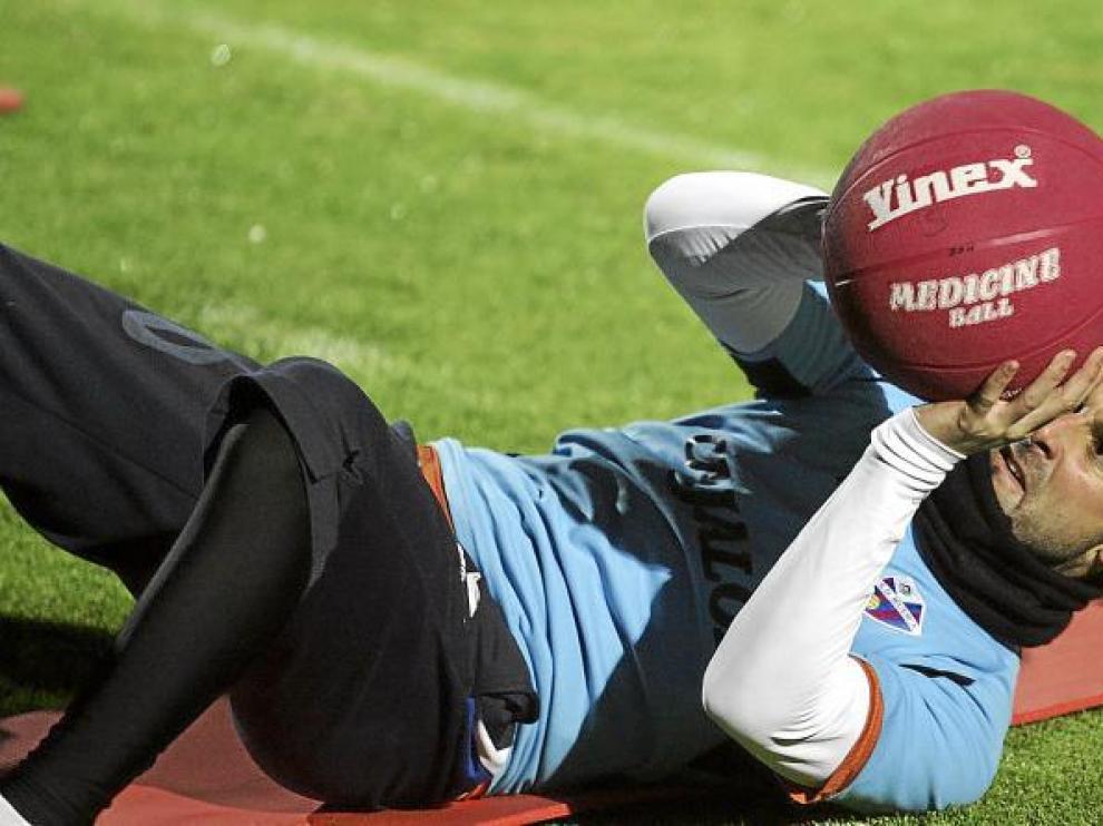 Toni Doblas levanta un balón medicinal en un entrenamiento del Huesca.