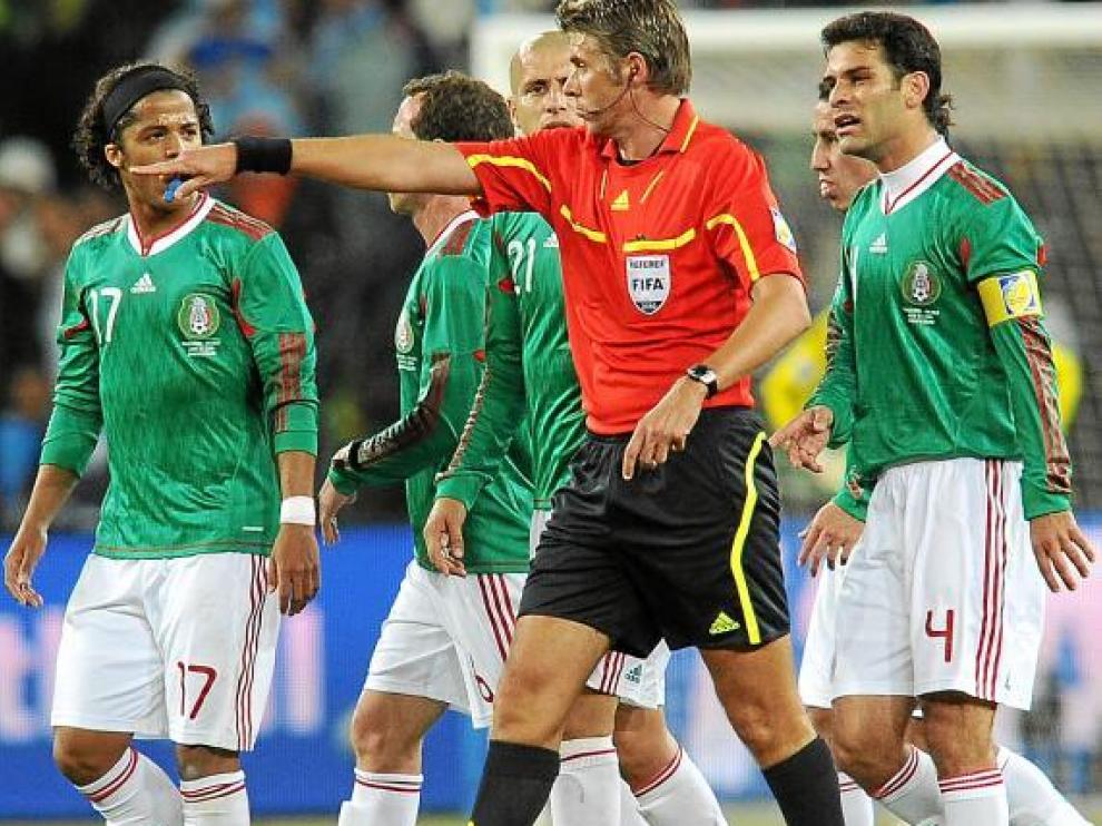 Roberto Rosetti, rodeado de jugadores mexicanos, tras el polémico gol en fuera de juego de Tévez.