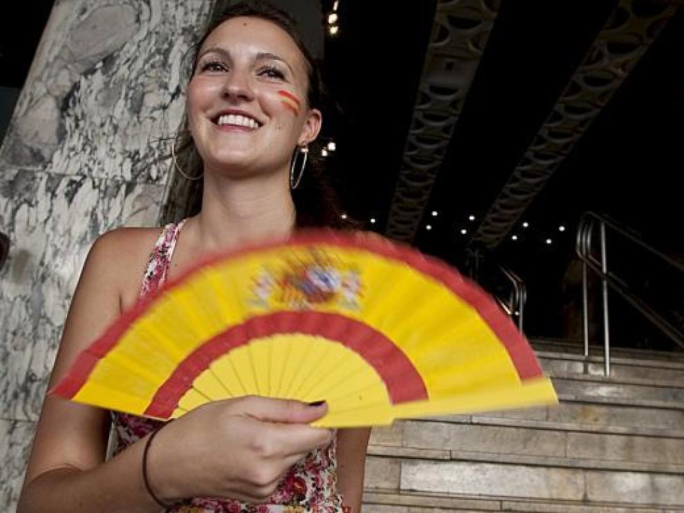 Una joven animadora de la selección española se abanica a la entrada de los cines Palafox.