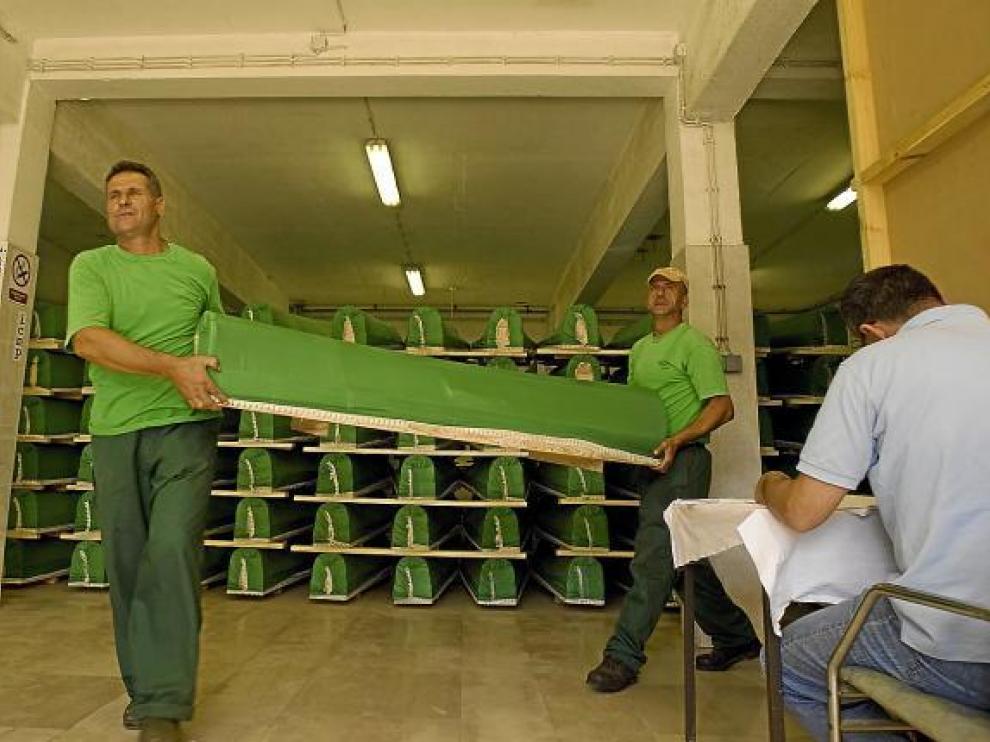 Dos trabajadores cargan un ataúd en Visoko.