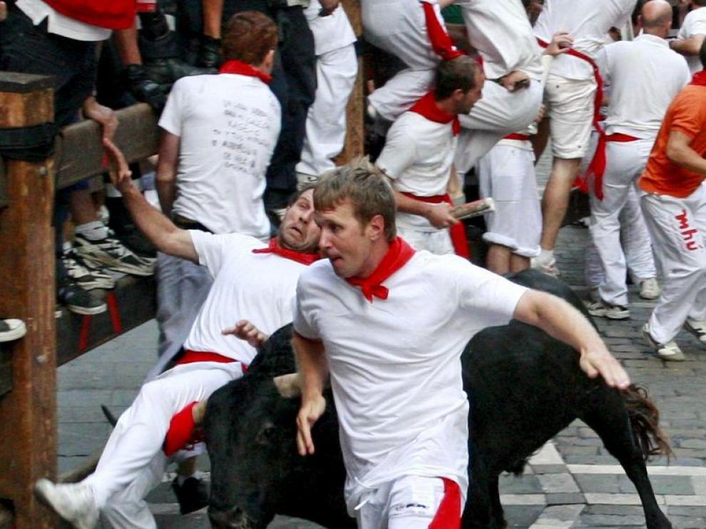 Los mozos intentan esquivar a uno de los toros
