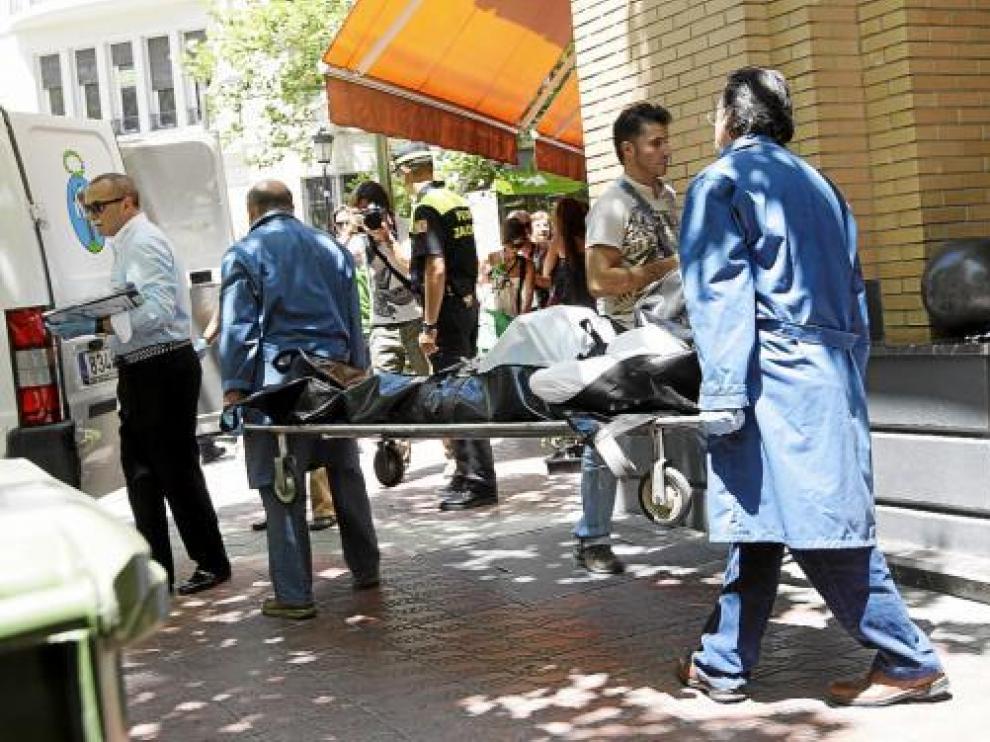 Momento en que los camilleros de la Sangre de Cristo se llevan el cadáver de la víctima.