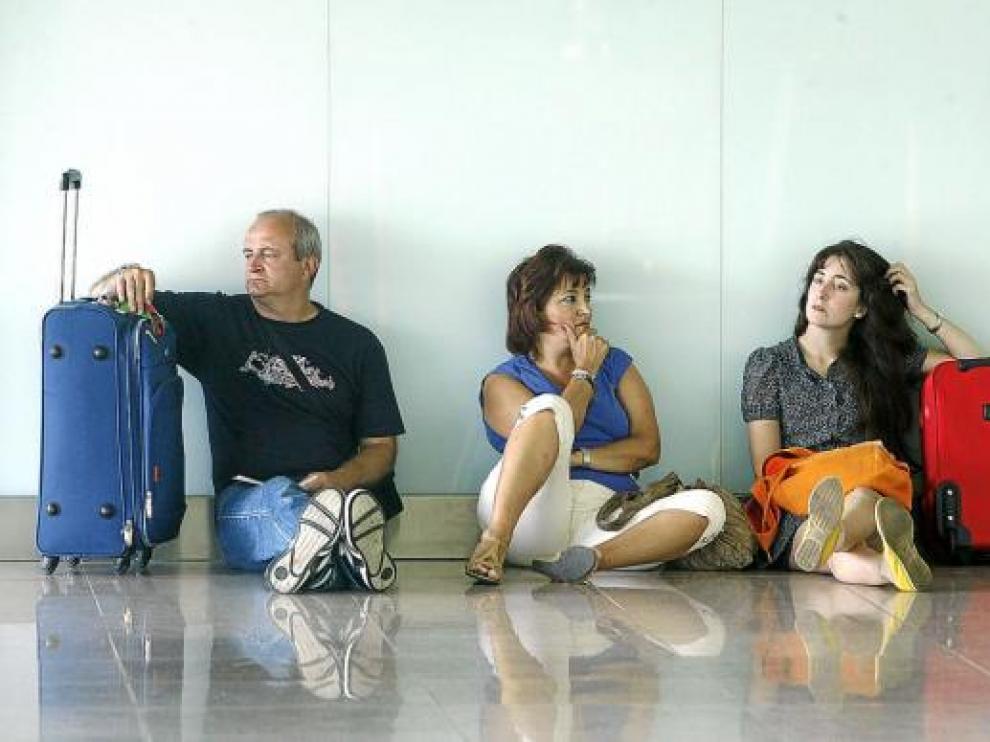 Varios pasajeros esperaban ayer en el aeropuerto del Prat, donde se repitieron los retrasos.
