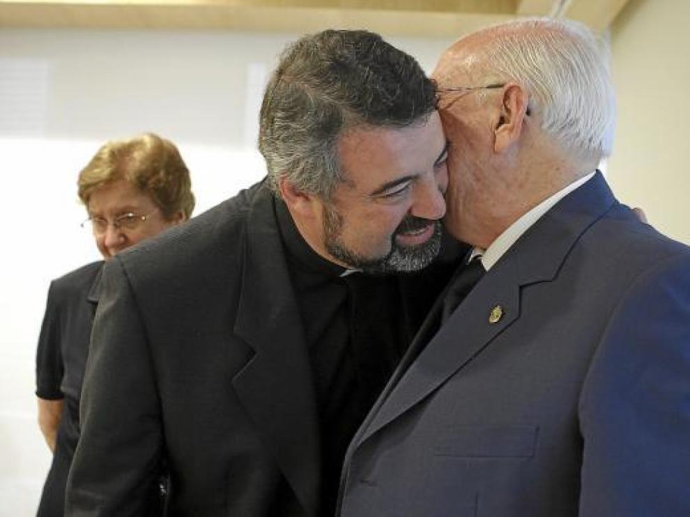 Carlos Escribano besa a su padre tras el anuncio de su nombramiento. Al fondo, su madre.