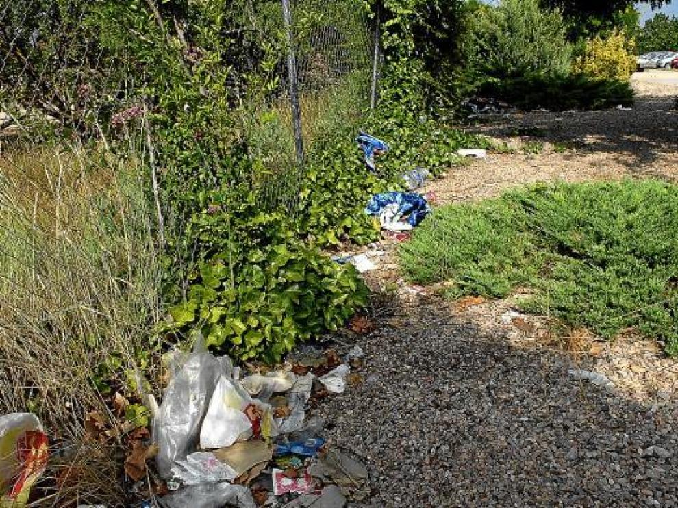La basura se concentra al lado de la valla de la piscina de los Planos.