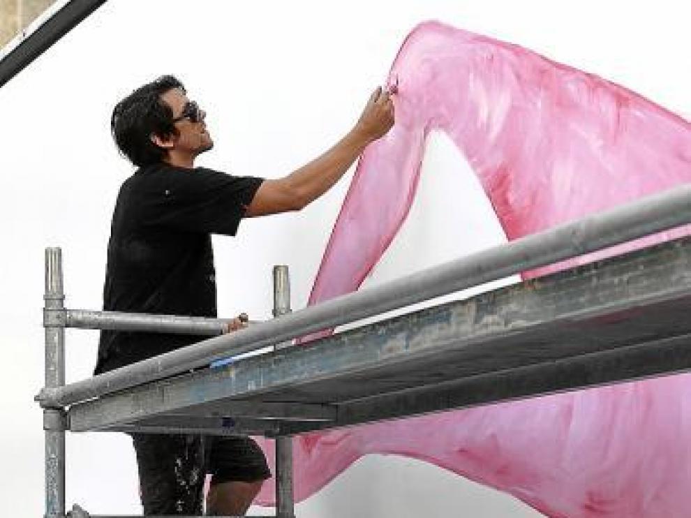 El pintor Leto colorea una de las lonas del camión.