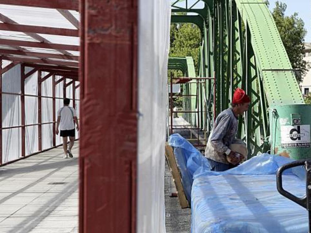 Los trabajos en los arcos que aún quedan por pintar y el pasadizo habilitado en el puente.