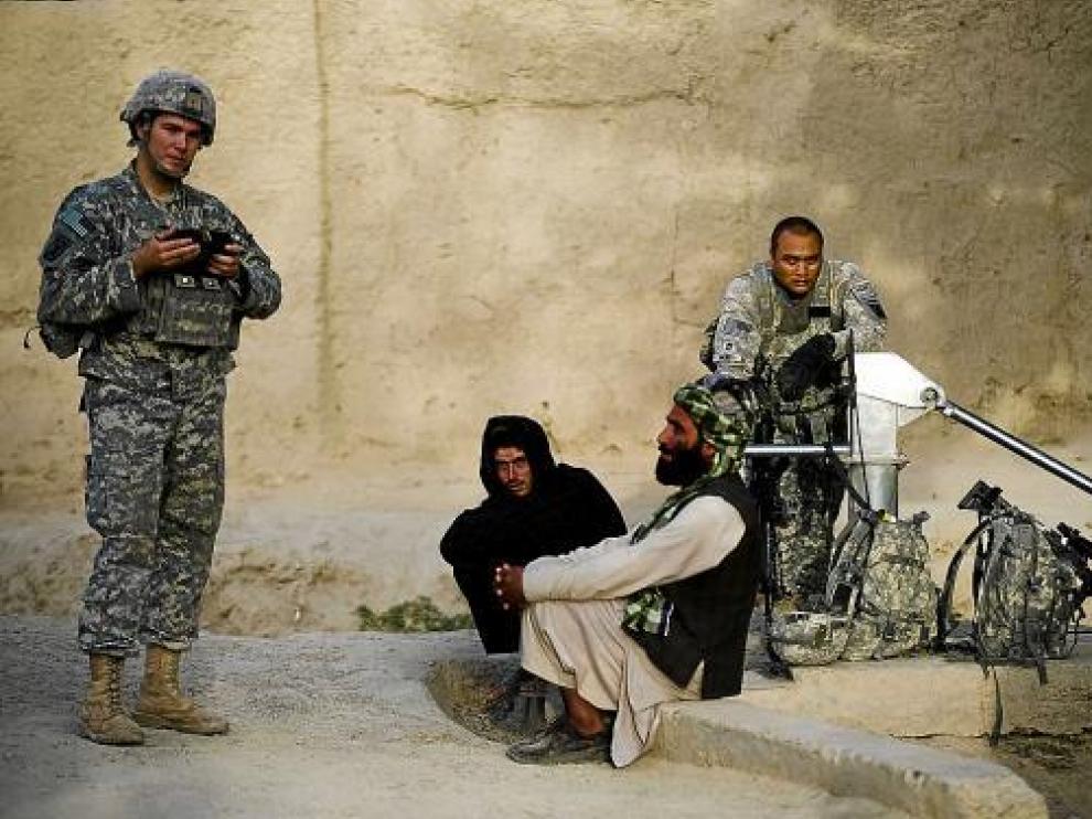 Dos soldados estadounidenses charlan con dos civiles afganos de la provincia de Kandahar.