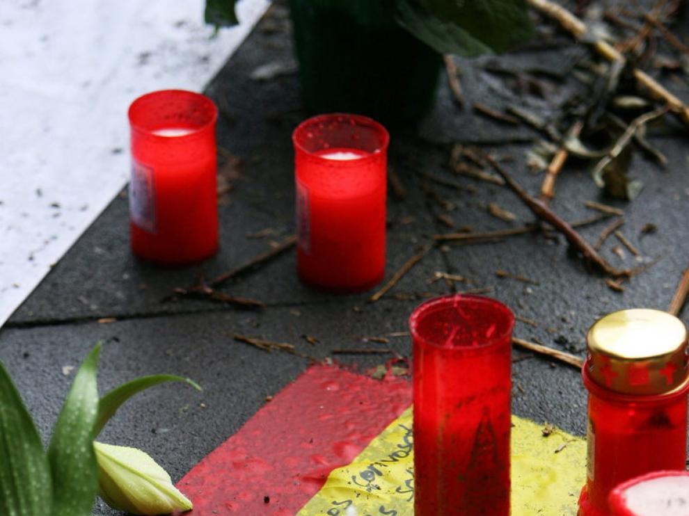 Velas sobre una bandera de España en el lugar donde murieron las jóvenes