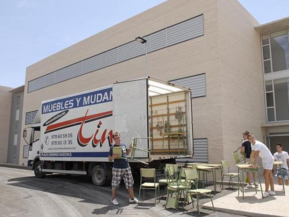 Los operarios de la mudanza transportan mobiliario al nuevo centro.