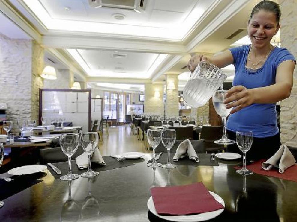 Mónica, camarera de la taberna Bílbilis, sirve agua del grifo en una copa.