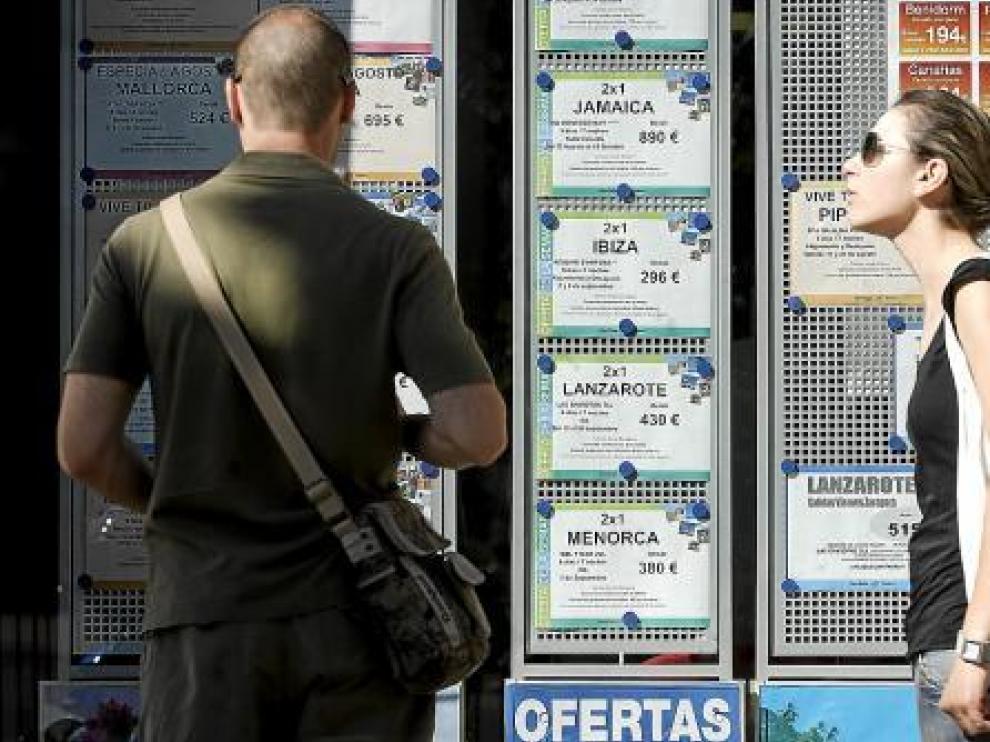 Dos jóvenes ojeaban ayer las ofertas de una agencia de viajes de Zaragoza.