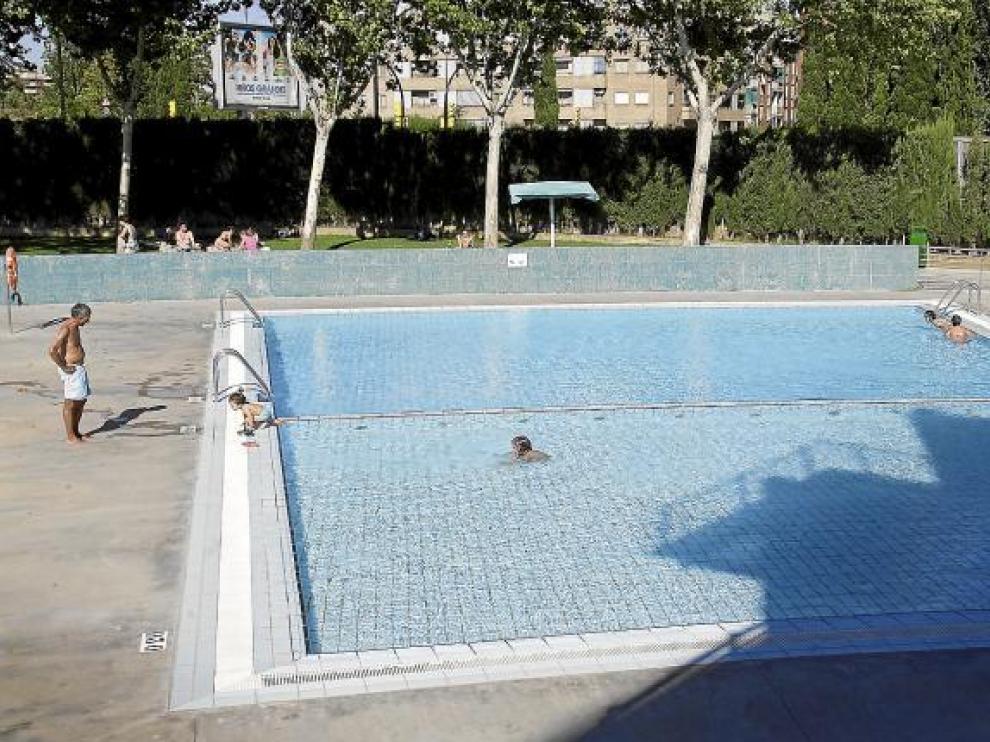 Dos niñas se bañan en el vaso de chapoteo del Alberto Maestro. Un adulto espera fuera.