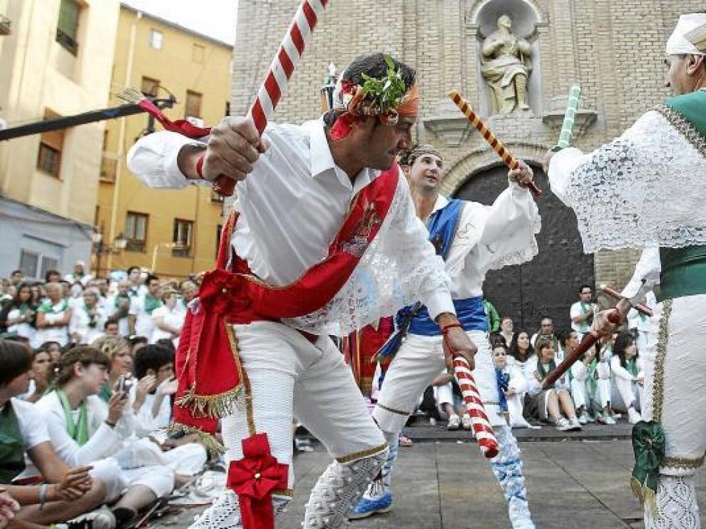 El público de las primeras filas sigue atento cada uno de los toques de una danza de palos nuevos, ante la basílica en la mañana de San Lorenzo.