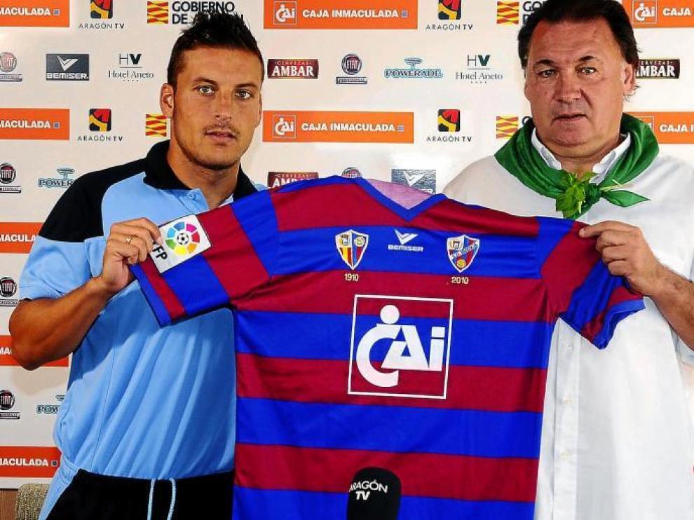 Marco Navas coge la camiseta del Huesca en compañía del vicepresidente de la entidad azulgrana, Agustín Lasaosa.