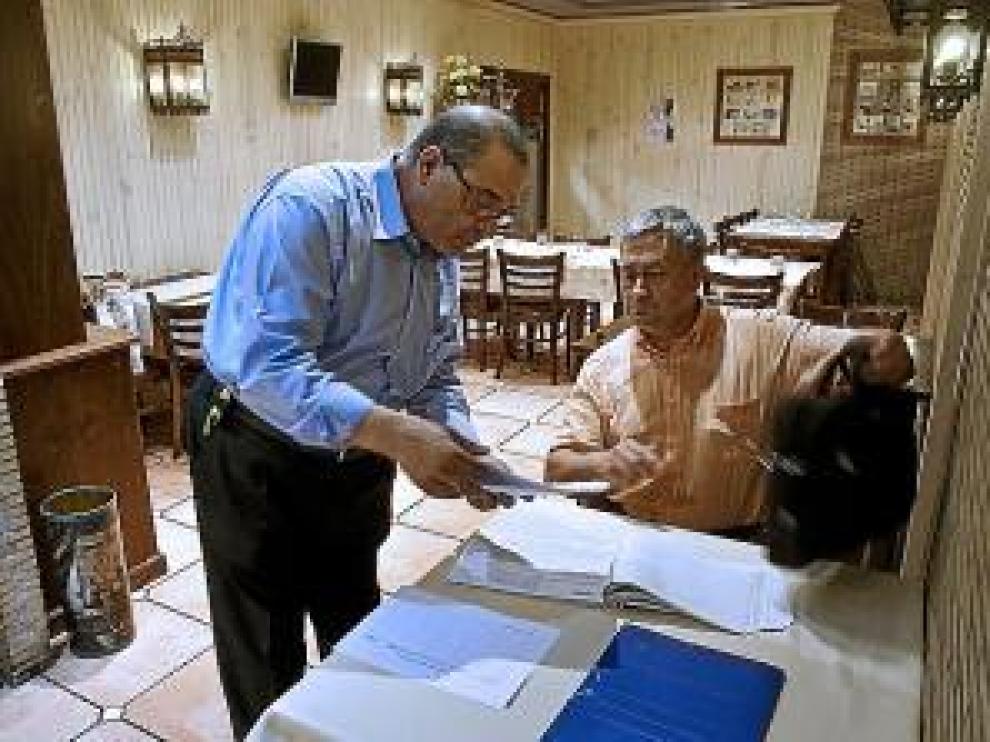 El encargado enseña los papeles al inspector.
