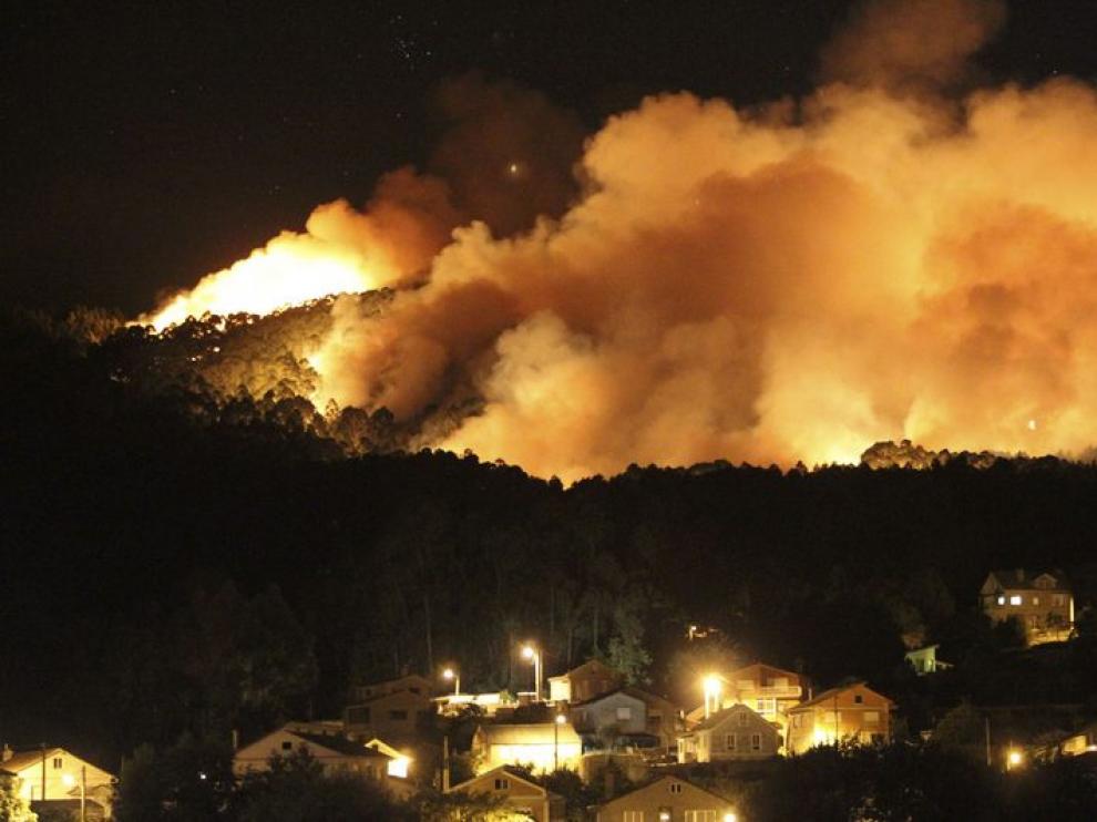 Vista del incendio forestal en los montes que rodean la parroquia de Baredo, en el municipio pontevedrés de Baiona