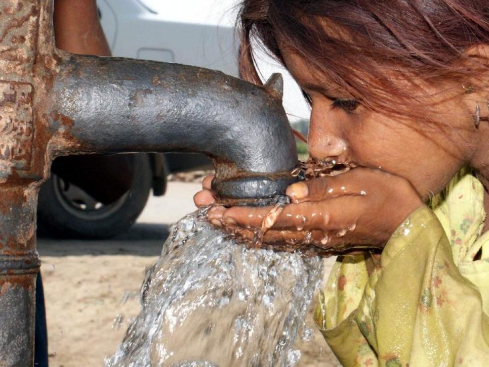 Una niña bebe agua en un campo de acogida a los afectados por las inundaciones