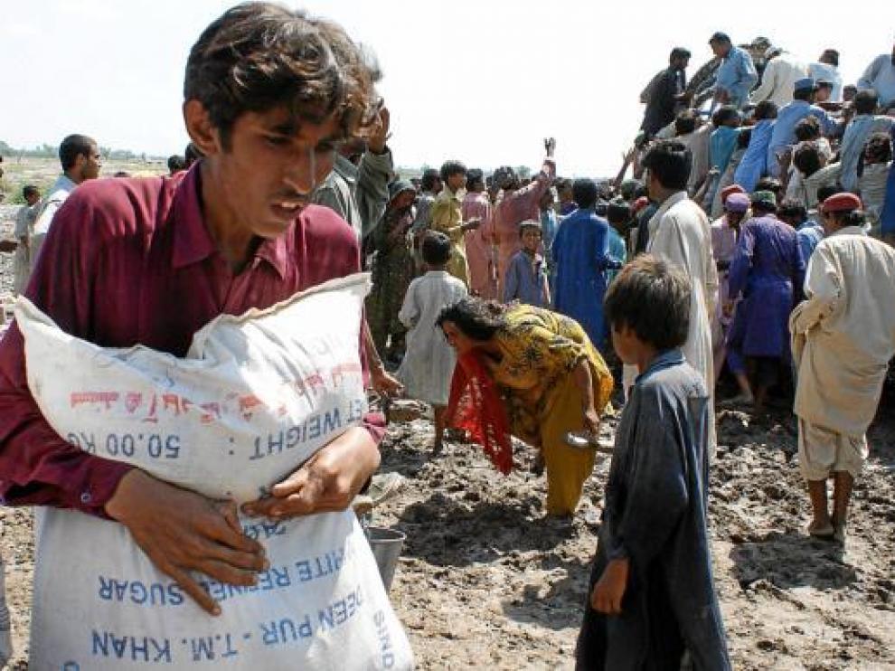 Víctimas de las inundaciones recogen la ayuda humanitaria en un campo de refugiados en Sukkur.