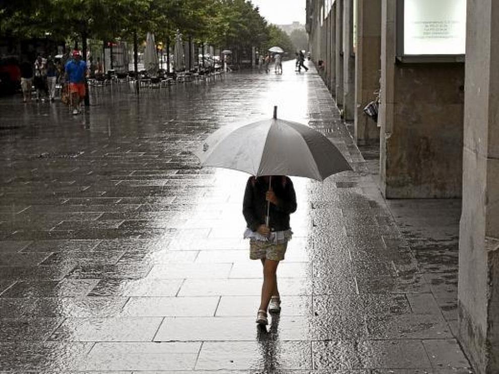 Una niña paseaba ayer cubierta con un paraguas por el paseo de la Independencia de Zaragoza.