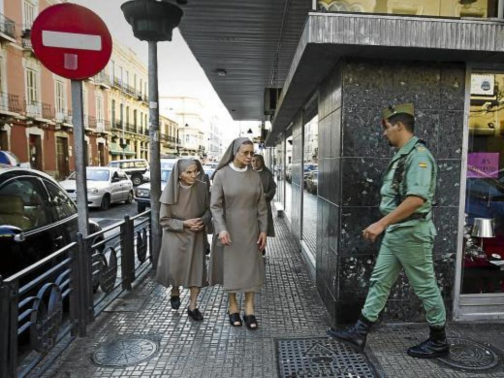 Varias monjas y un legionario caminan por el centro de Melilla, donde ha vuelto la normalidad.