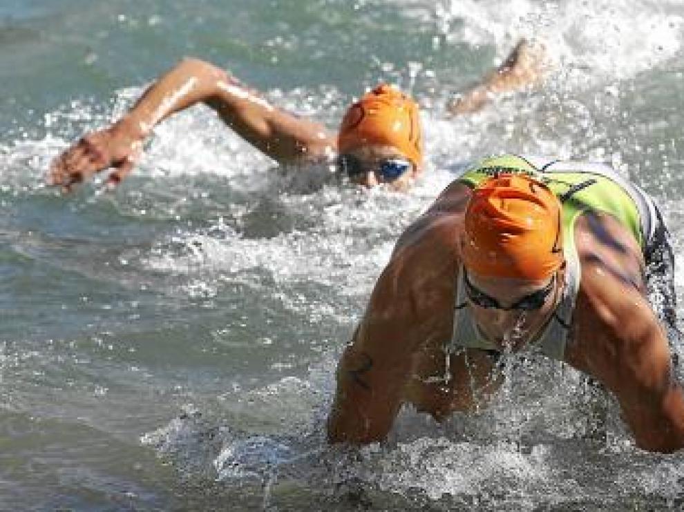 Dos participantes nadan en la primera prueba del triatlón.