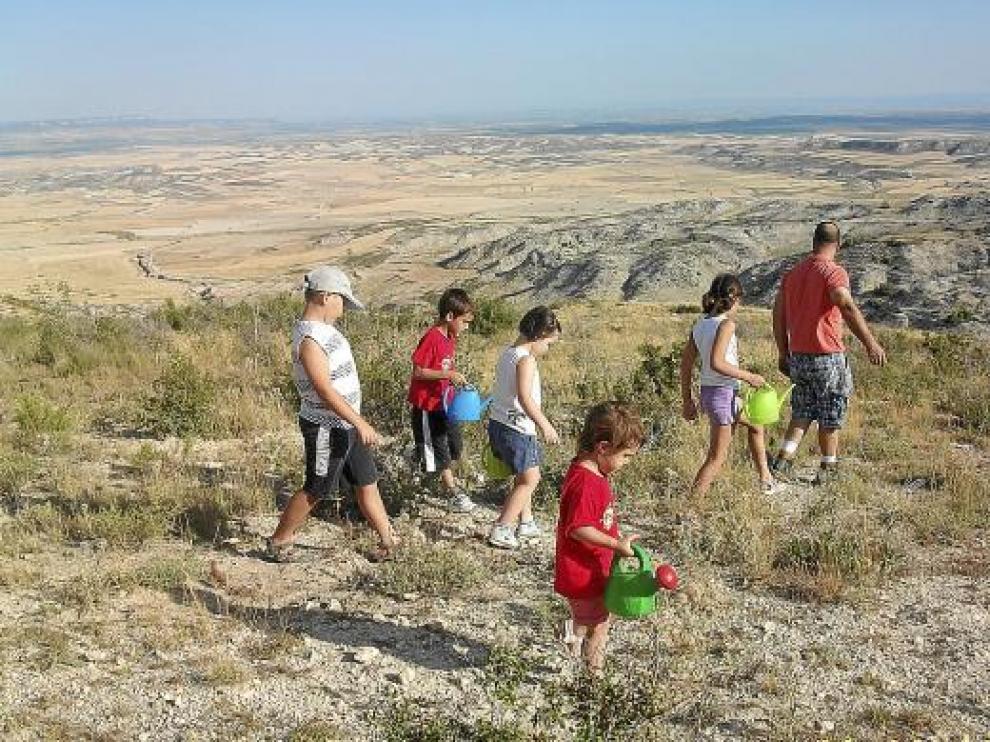 Los niños también participaron en la regada popular en el Monte Alto de Tauste.