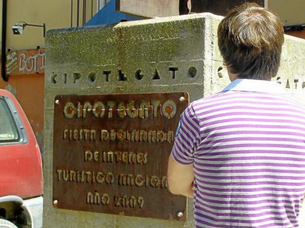 El Cipotegato, de espaldas para mantener su anonimato, junto a la estatua de su personaje.