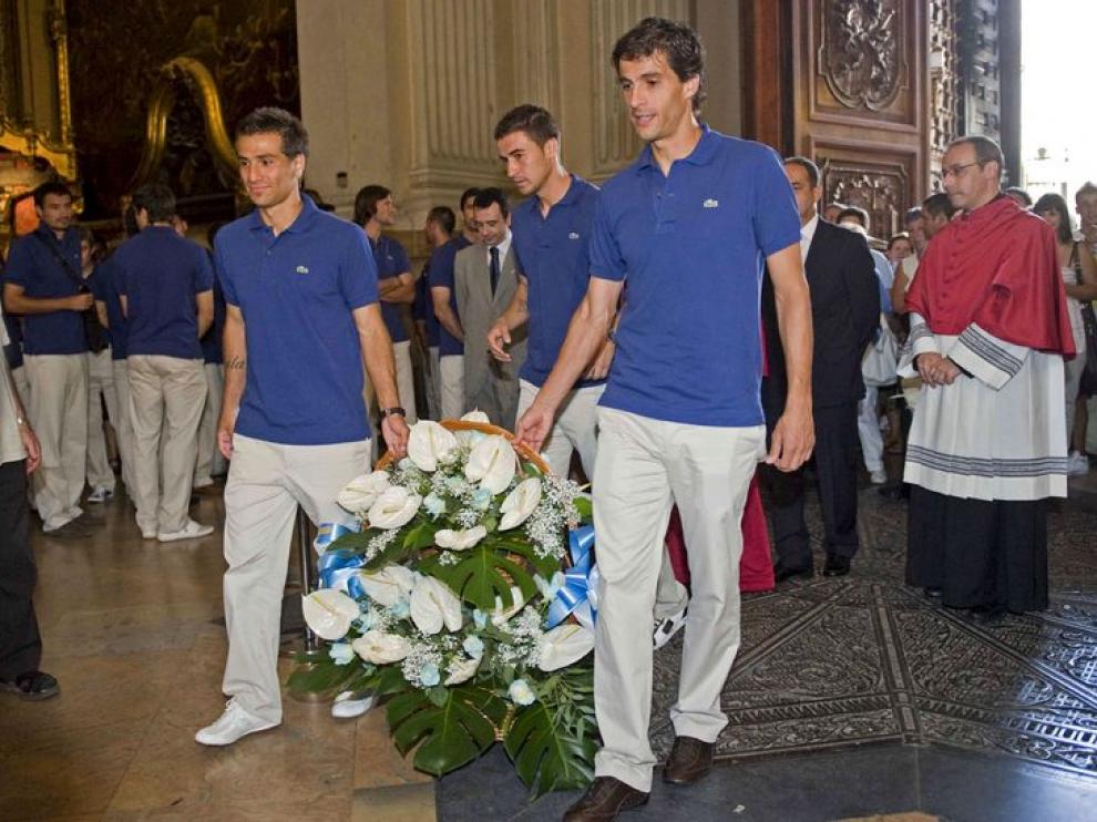 Ponzio, Jorge López y Gabi portan el centro de flores ofrecido a la Virgen del Pilar.