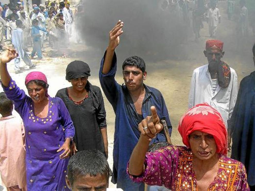 Varios desplazadas queman neumáticos ante la falta de provisiones en Larkana, ayer.