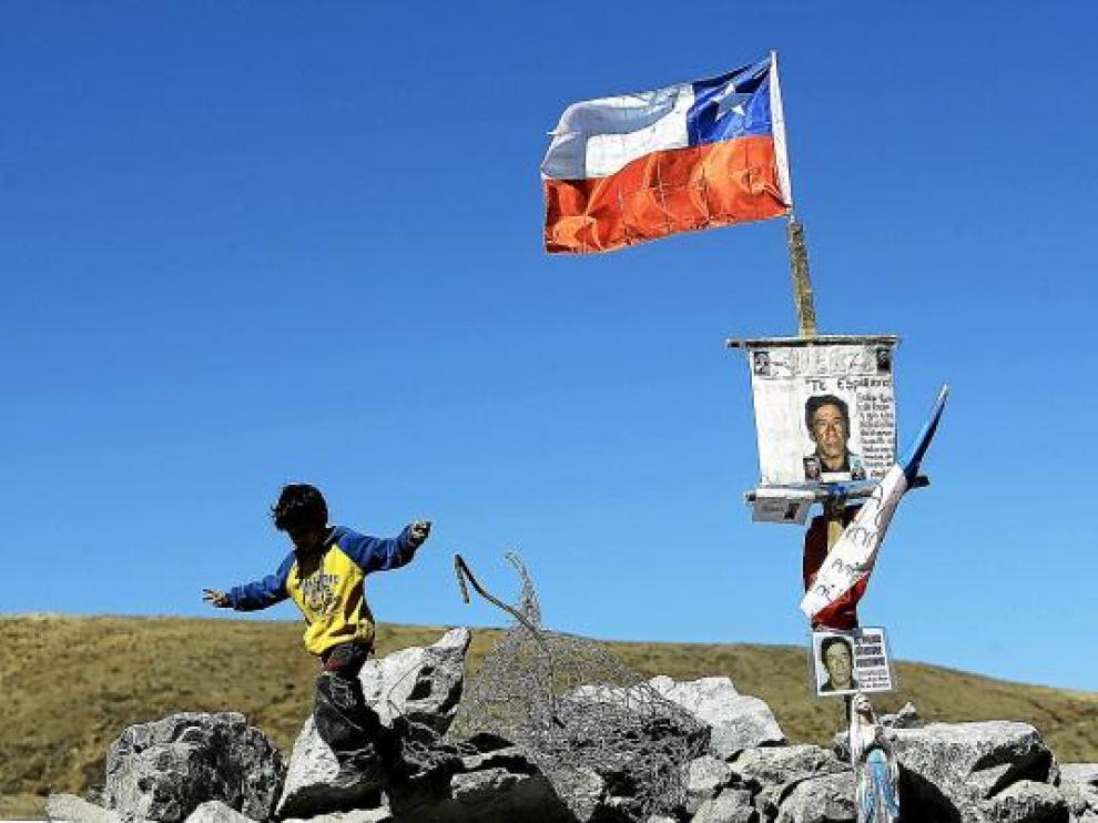 Un niño camina, ayer, junto a un altar dedicado al minero Yonny Barrios, uno de los atrapados.