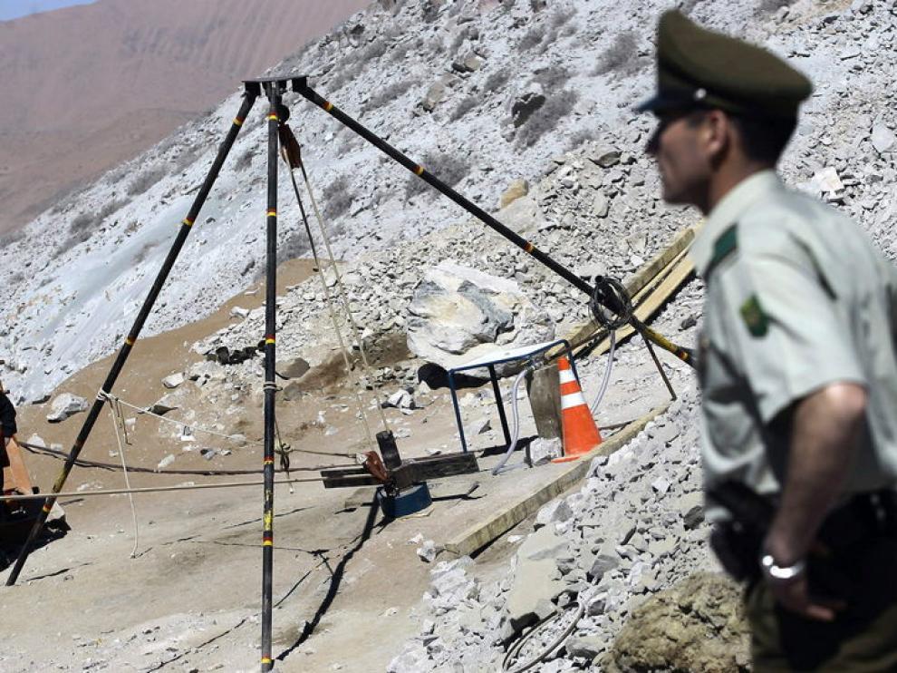 Un policía custodia un ducto que conduce hasta los mineros atrapados