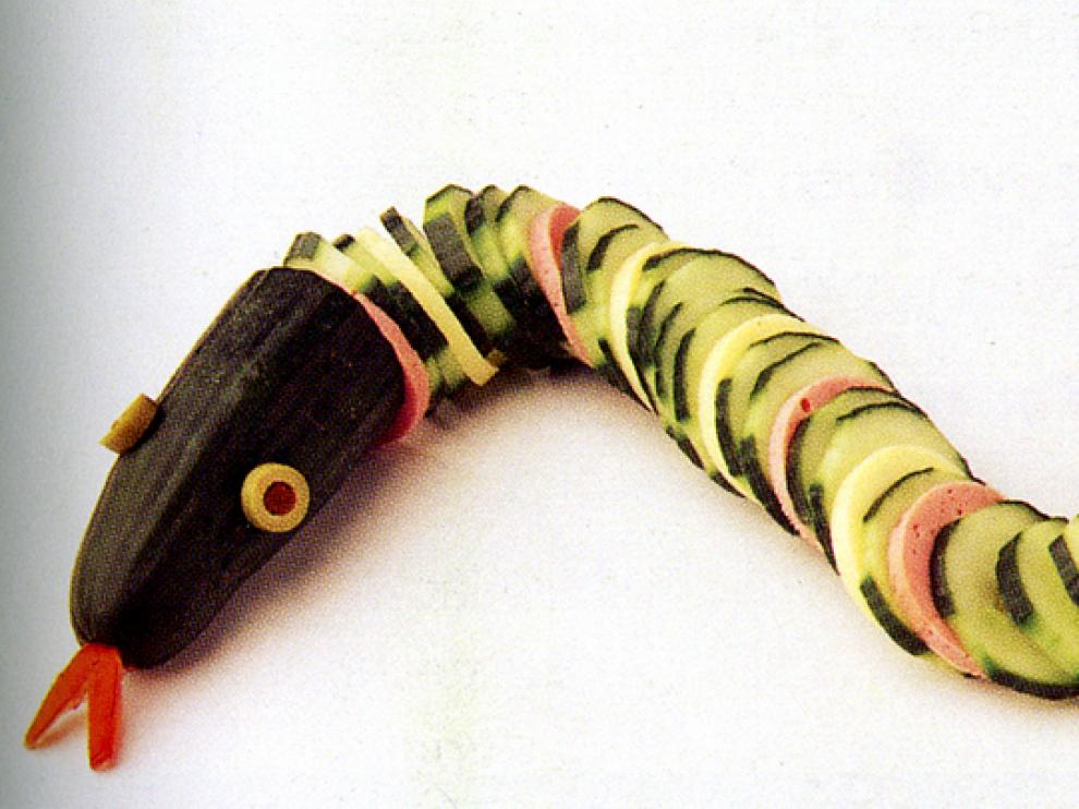 Una serpiente hecha con rodajas de pepino, mortadela y aceitunas para los ojos