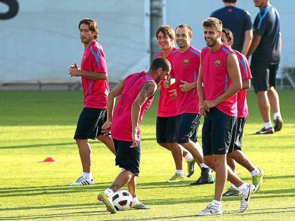 Dani Alves juega con el balón, durante un entrenamiento del Barcelona.