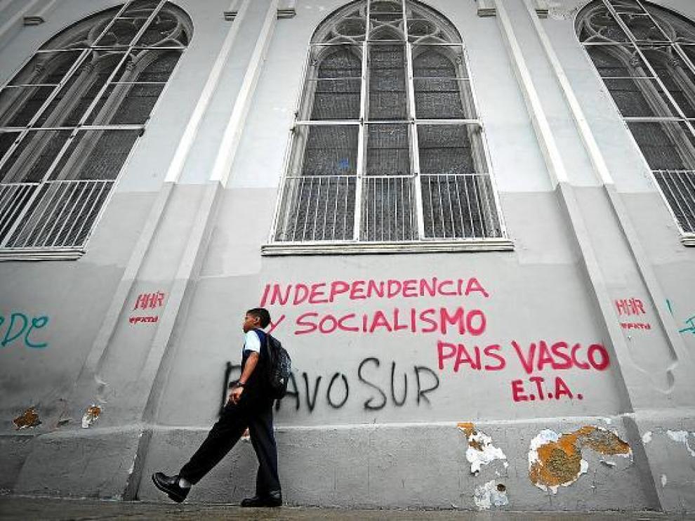 Un chico pasea ante un edificio con pintadas a favor de ETA, ayer en Caracas.