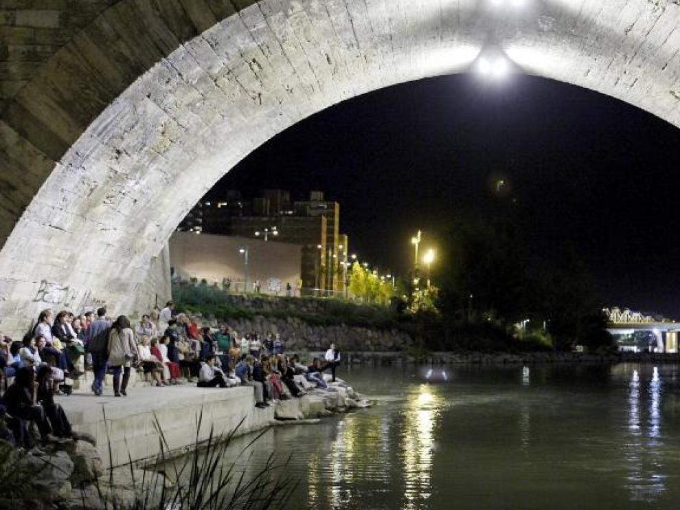 Los intérpretes llegaron en barca mientras el público se arremolinaba en las orillas, bajo el puente y en el Balcón de San Lázaro.