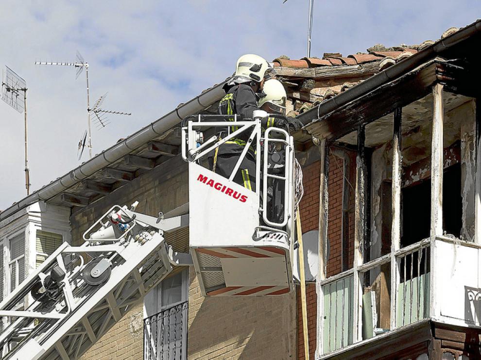Unos bomberos trabajan en la vivienda donde se produjo ayer el suceso.