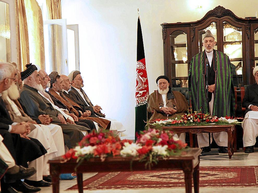 Karzai (2d) reza durante la apertura del Consejo de Paz, ayer.
