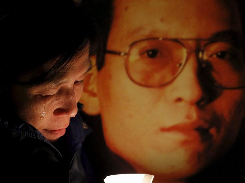 Una activista llorando junto a una foto del disidente chino Liu Xiaobo.